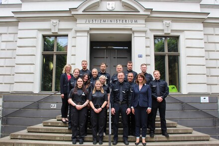 Justizministerin Jacqueline Bernhardt (rechts), die stellvertretende Leiterin der Abteilung Justizvollzug Gloria Arndt (links) und die AVD-Klasse I 2024.