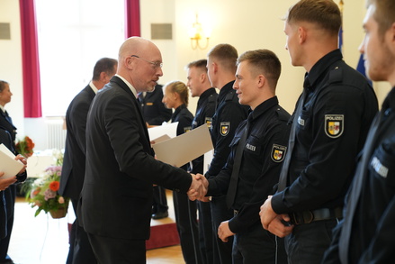 Foto-Quelle: IM MV _ Innenminister Christian Pegel (l.) beglückwünscht die neuen Polizeimeisterinnen und –meister.