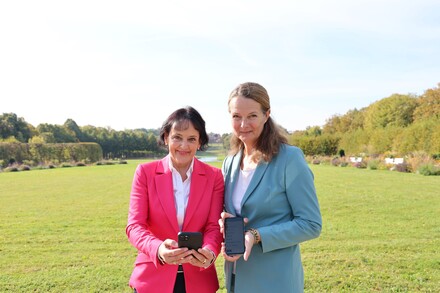 Kulturministerin Bettina Martin (r.) und die Direktorin der Staatlichen Schlösser, Gärten und Kunstsammlungen, Dr. Pirko Zinnow, stellten im Schweriner Schlossgarten die neuen Funktionalitäten der App vor.