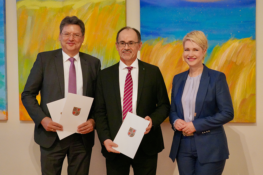 Ministerpräsidentin Manuela Schwesig mit dem vormaligen Minister Reinhard Meyer und dem neu ernannten Minister Dr. Wolfgang Blank. Die Herren halten ihre Urkunden in der Hand.