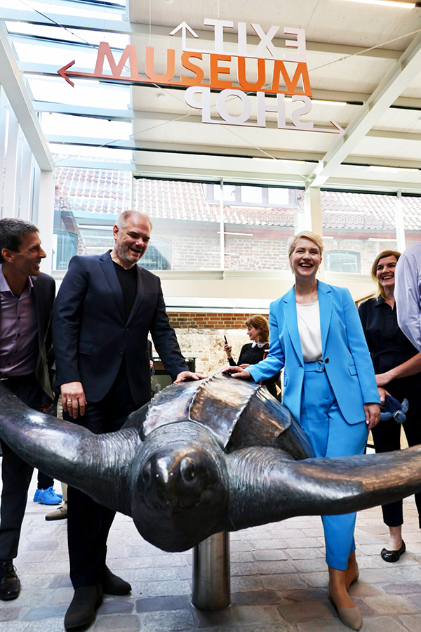 Modell einer großen Schildkröte im Stralsunder Meeresmuseum. Ministerpräsidentin Manuela Schwesig und Stralsunds Oberbürgermeister Dr. Alexander Badrow legen eine Hand auf deren Panzer.