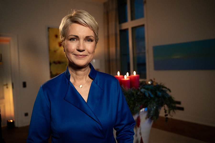 Ministerpräsidentin Manuela Schwesig bei ihrer Weihnachtsansprache. Im Hintergrund ist ein Adventskranz mit Kerzen zu sehen.